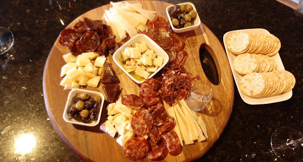 A charcuterie board at La Vid: sliced chorizo, cheeses, olives, and crackers